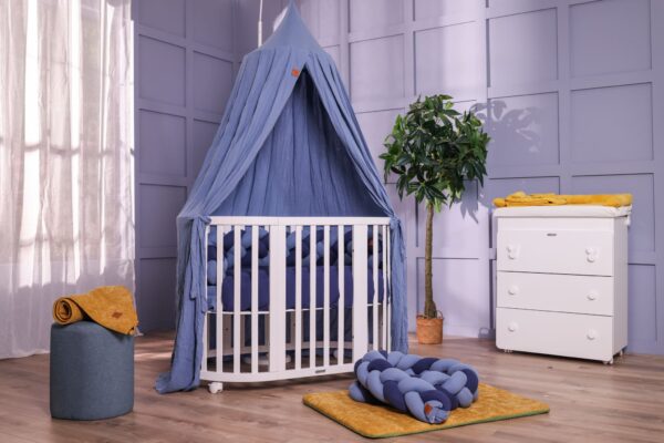 Cameretta per neonato azzurra con lettino bianco e baldacchino in mussola di cotone azzurro, piumone double face e fasciatoio bianco con fasciatoio tessile in spugna di bamboo senape